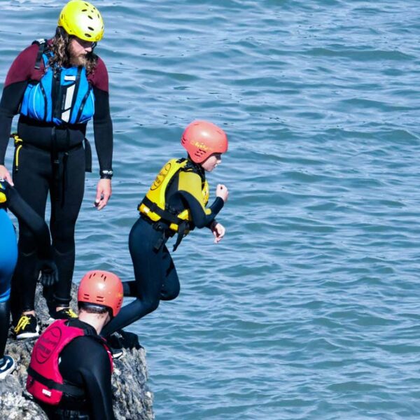 Group on rocks jumping into the sea