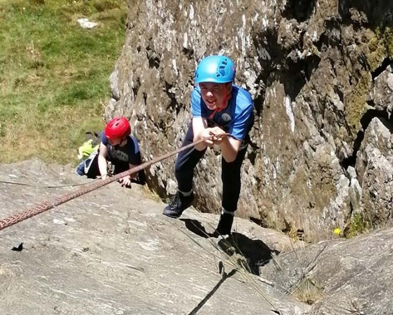 Teenager boy rock climbing in donegal.