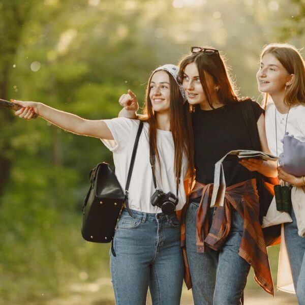 three teenage girls orienteering in the forest