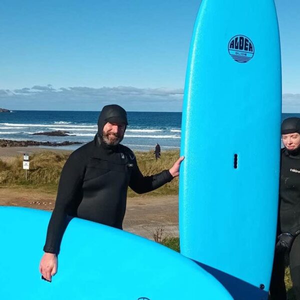 Eco Atlantic Surfers with Surfboards in Donegal Landscape